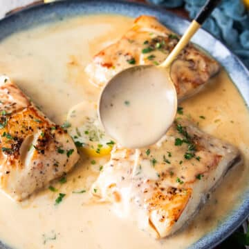 A spoon pouring some cream butter sauce over the black cod recipe to flavor it