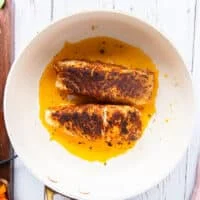 charred and seared cajun spiced halibut or chicken in a skillet