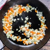 a cast iron skillet with minced onions and peppers