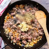 The ground beef, mined garlic and taco seasoning are added to the skillet to make the taco meat mixture