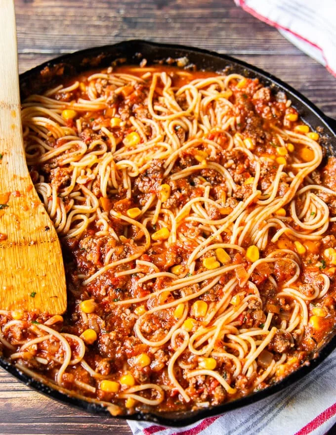 The spaghetti and meat sauce are tossed together in the skillet