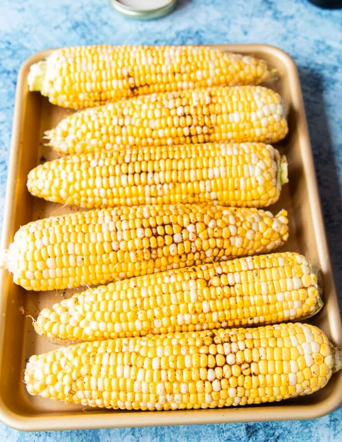 fresh seasonal corn on the cob seasoned and ready to grill