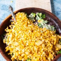The corn kernels are added to the salad bowl along with avocados and cotija cheese