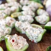 close up of the tuna cucumber salad cut up and served on a wooden board