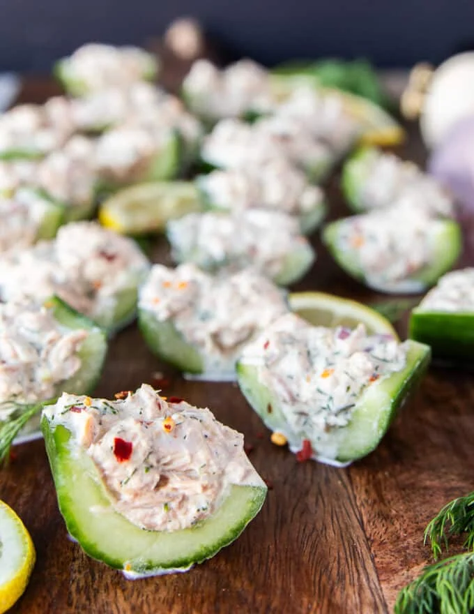close up of the tuna cucumber salad cut up and served on a wooden board