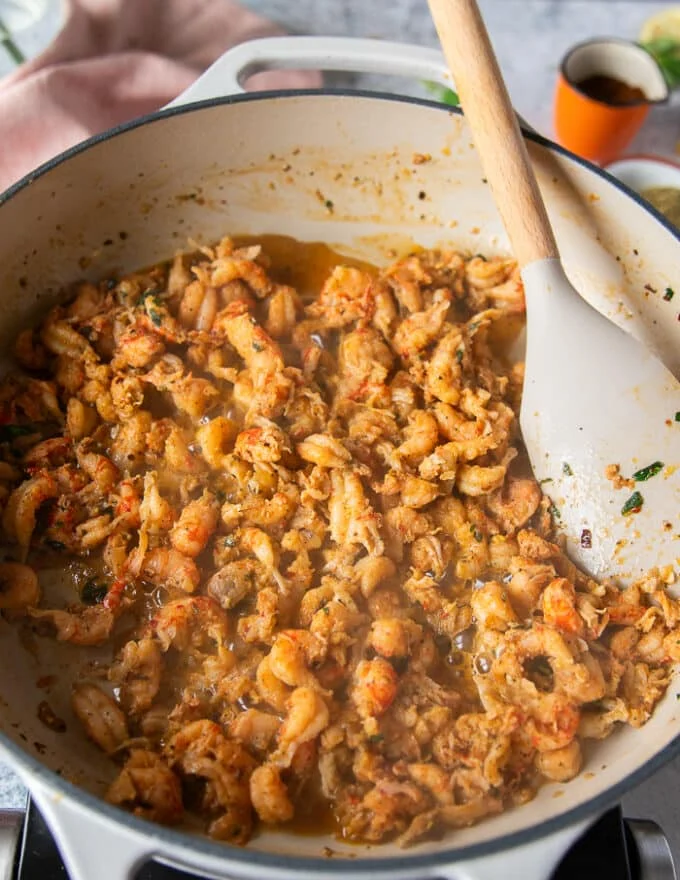 The crawfish tail meat is cooking in the skillet and has absorbed all the flavors