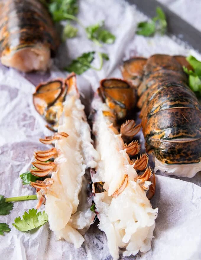 A lobster tail split in half with the meat inside ready to season