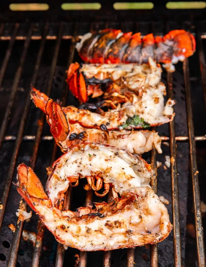 The flipped lobster tails on the grill with perfect grill marks