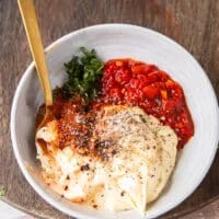Ingredients to make harissa aioli all added into one bowl and a spoon on the side to mix them up