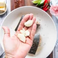 whole smashed garlic cloves added to a pan