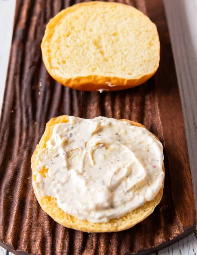 Lemon aioli is spread over the buns to assemble the salmon burgers
