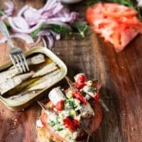 Feta cheese, herbs, hot sauce dollops, preserved lemons or regular lemon, dill are added over the sardines