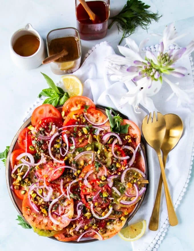 tomato carpaccio on a plate with fresh basil and olive oil