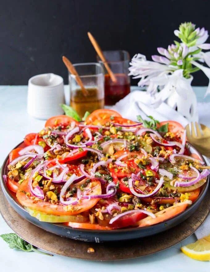 carpaccio recipe on a wooden bowl and lots of olive oil and basil