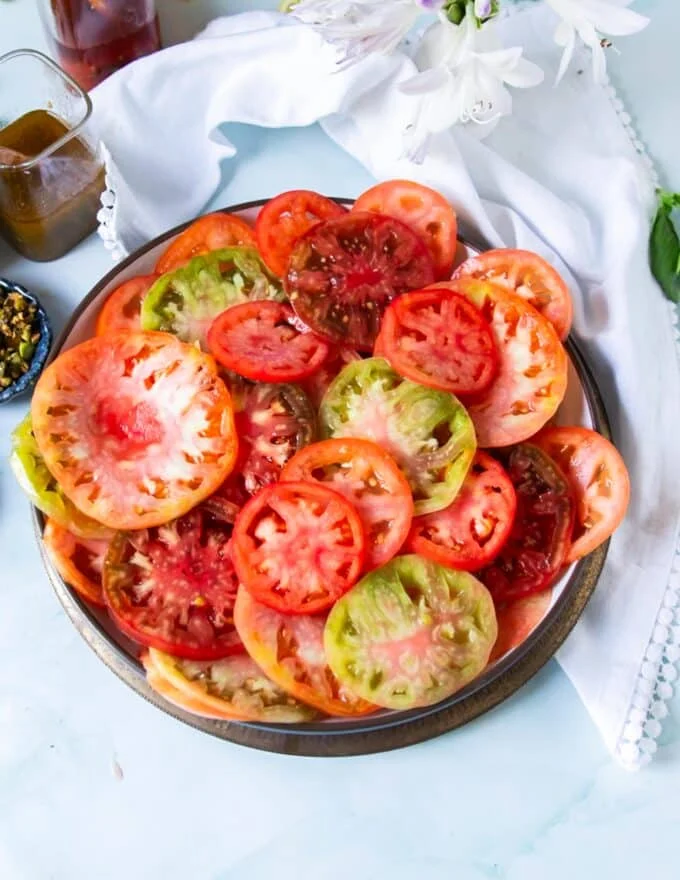 overlapping multicolored heirloom tomatoes on a bowl