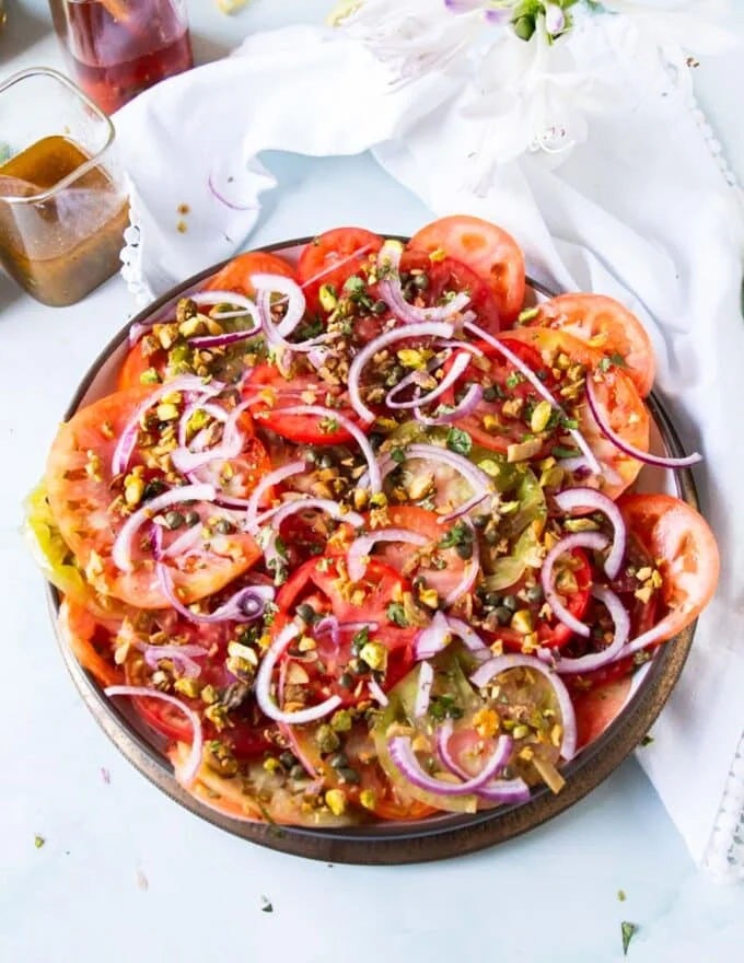 All the toppings added over the tomato carpaccio plate
