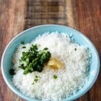 A bowl with parmesan , garlic and parsley