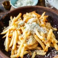 half of the parmesan mixture is added first to flavor the fries