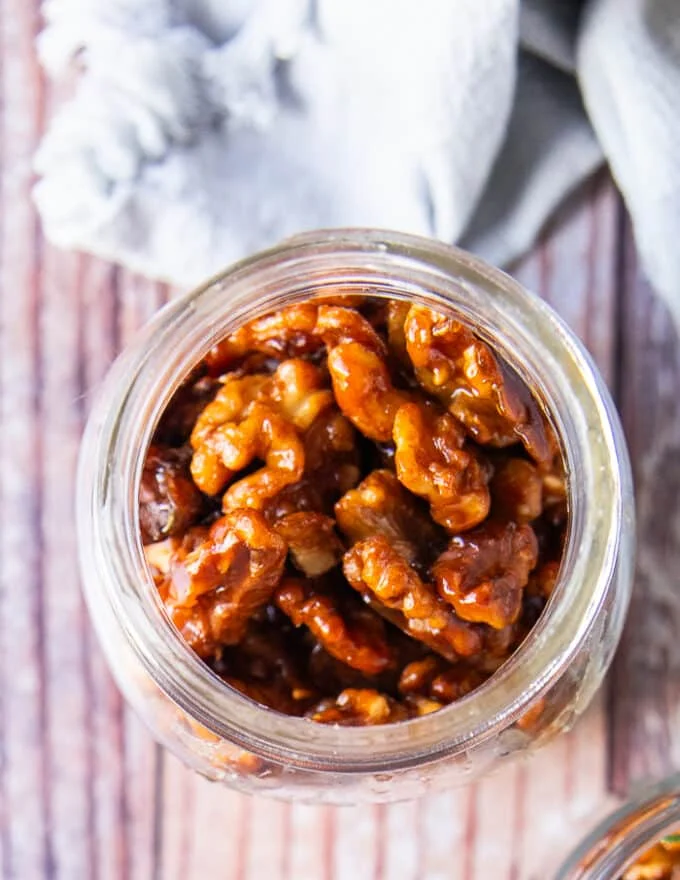 Close up of a jar filled with candied walnuts ready to store