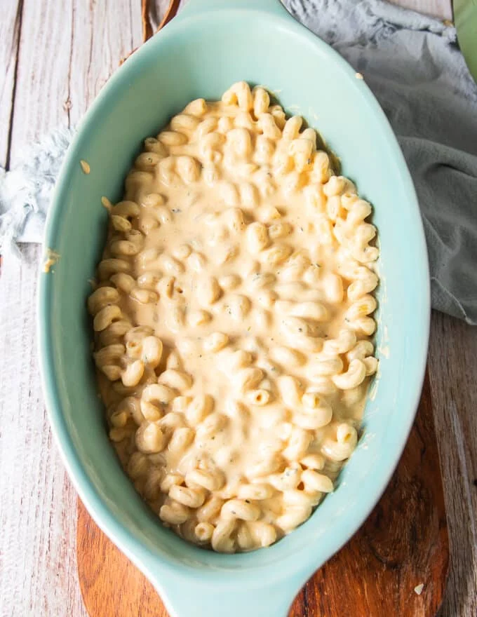half the pasta in an oven safe dish spread