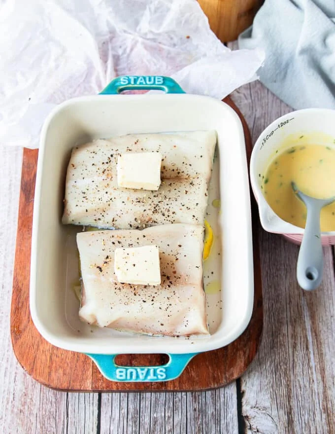 Butter is added over each fillet in the baking dish right before baking