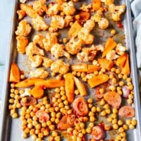 Seasoned veggies on a baking sheet ready to roast to make cauliflower salad