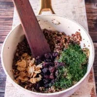 adding cranberries and toasted almonds, and herbs to the pilaf