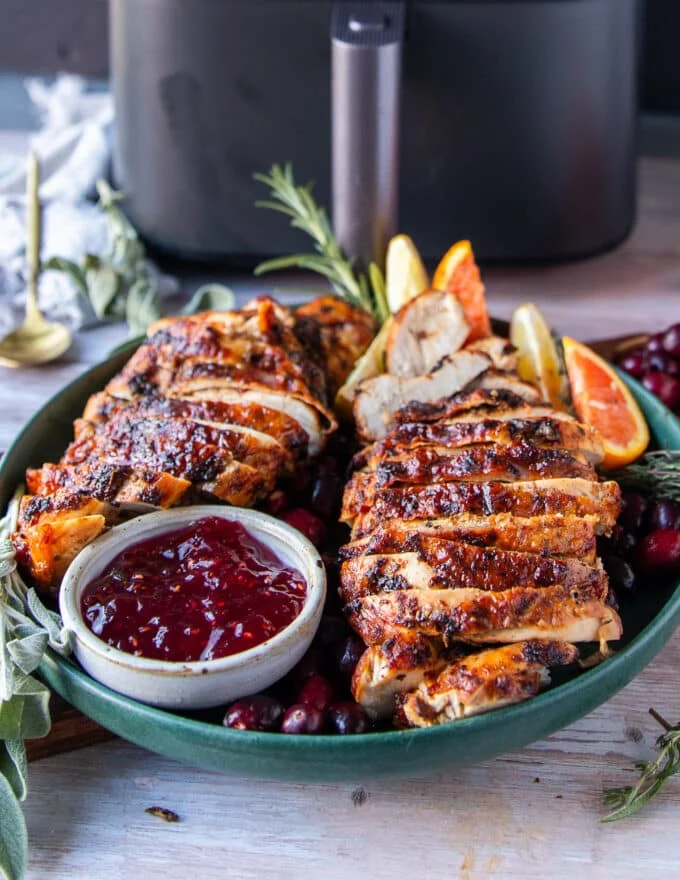 Juicy air fryer turkey breasts, sliced with crispy skin served with cranberry sauce