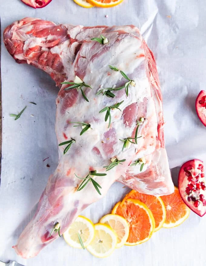 Fresh rosemary and garlic cloves inserted in the incisions along the lamb shoulder.