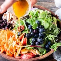 maple vinaigrette being poured over the salad