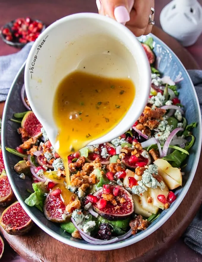 salad dressing is poured over the salad