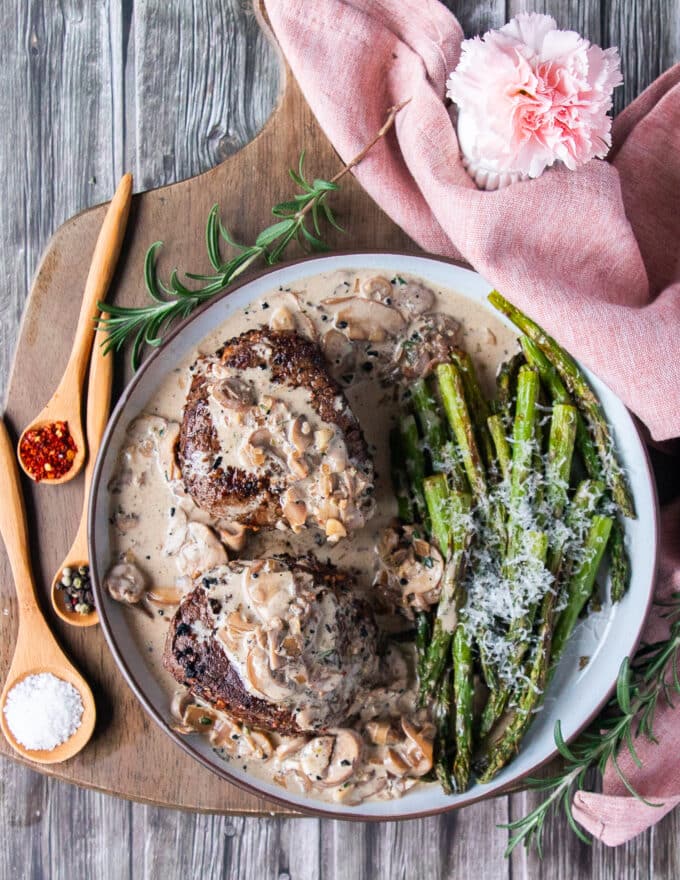 Perfectly cooked filet mignon recipe on a plate with some asparagus