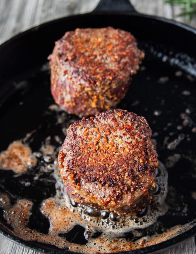 filet mignon searing in a hot pan until golden