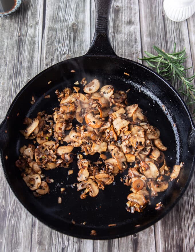 golden brown mushrooms cooking in the same skillet of the steak