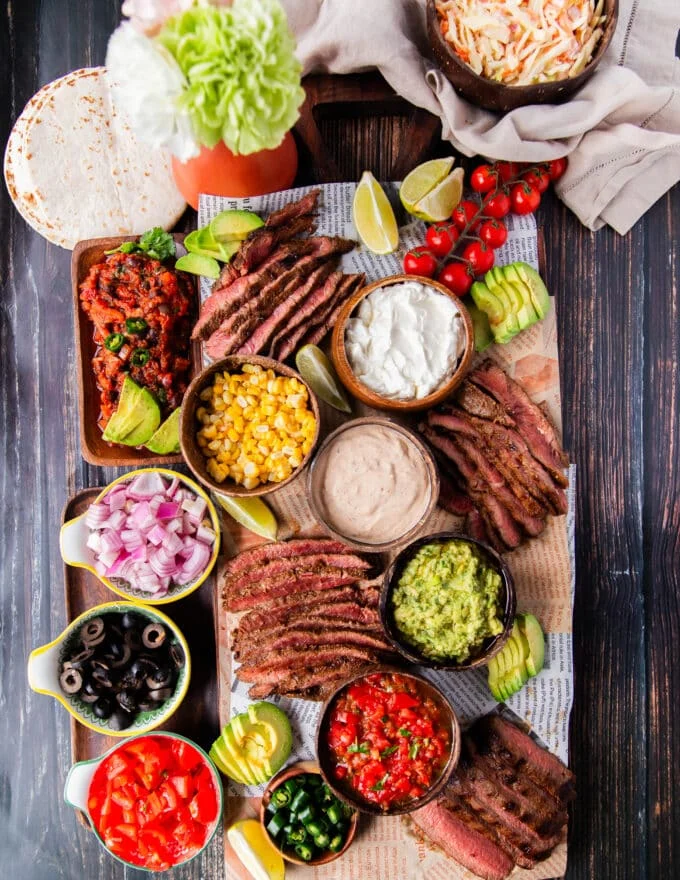 Flank Steak tacos all laid out in a taco board to allow each person to assemble their own