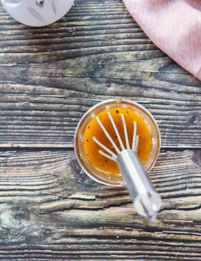 maple vinaigrette ingredients combined in a jar and whisk is used to emulsify