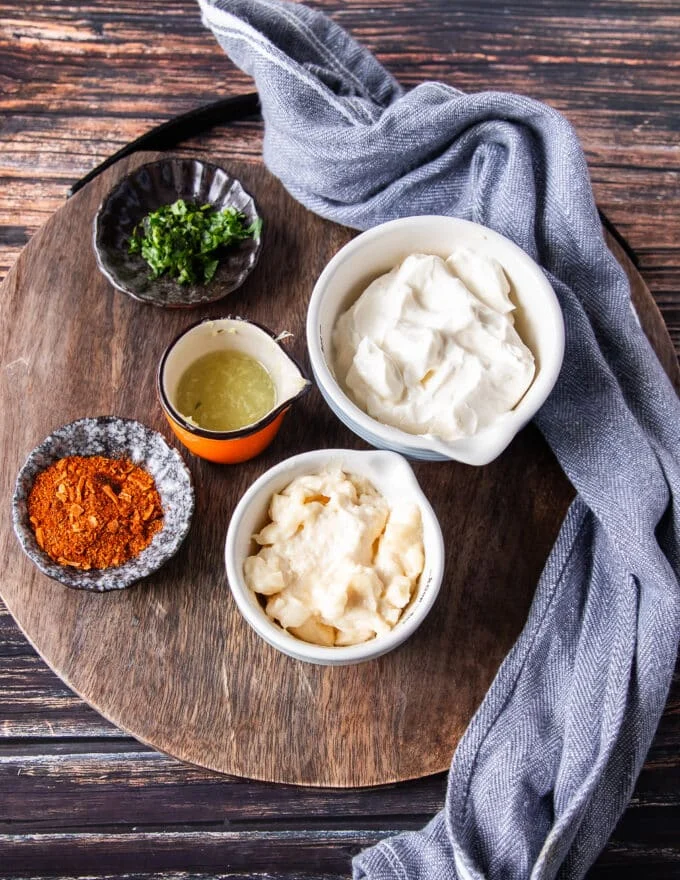 ingredients to make taco sauce on a board in small bowls