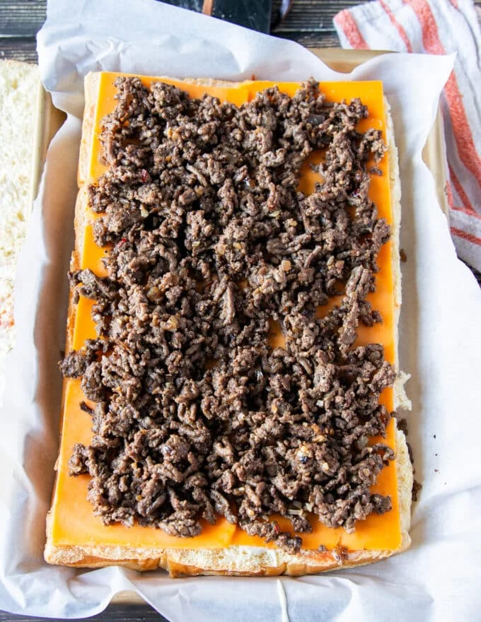 burger meat is added over the cheese