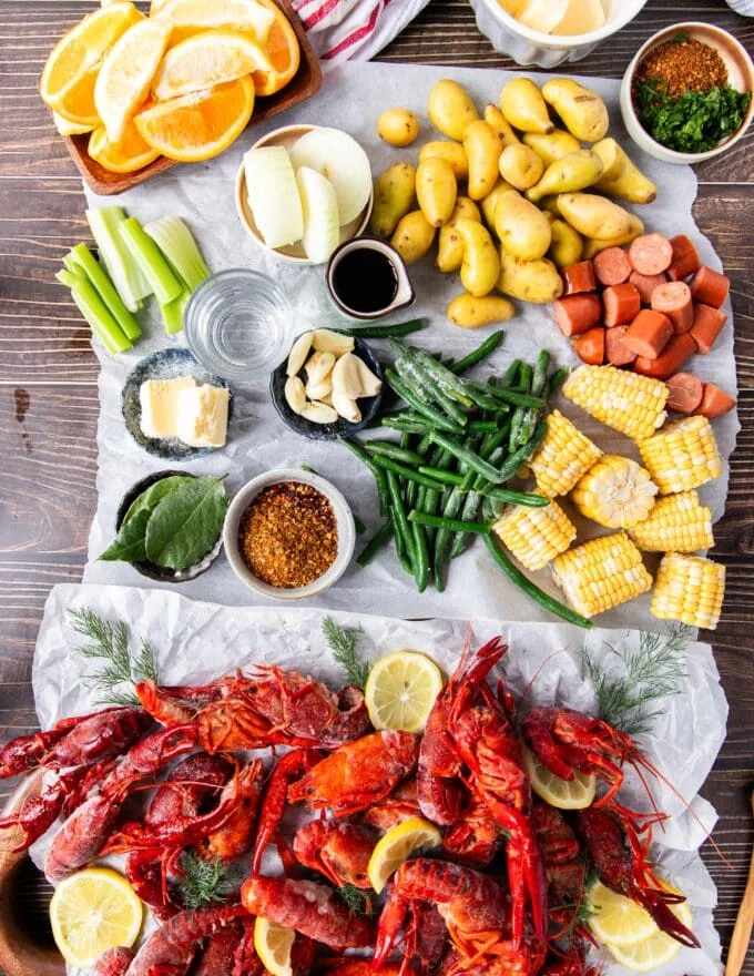 Ingredients needed to make crawfish boil over a newspaper.