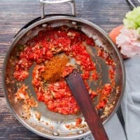 Tomatoes and seasoning are added to the sauce pan