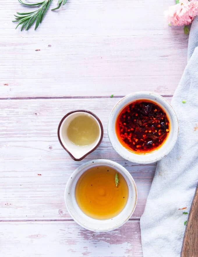 salad dressing ingredients in small bowls on a board