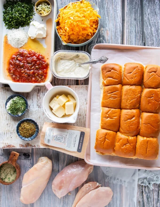 All ingredients in small bowls to make chicken sliders along with slider bread on the side