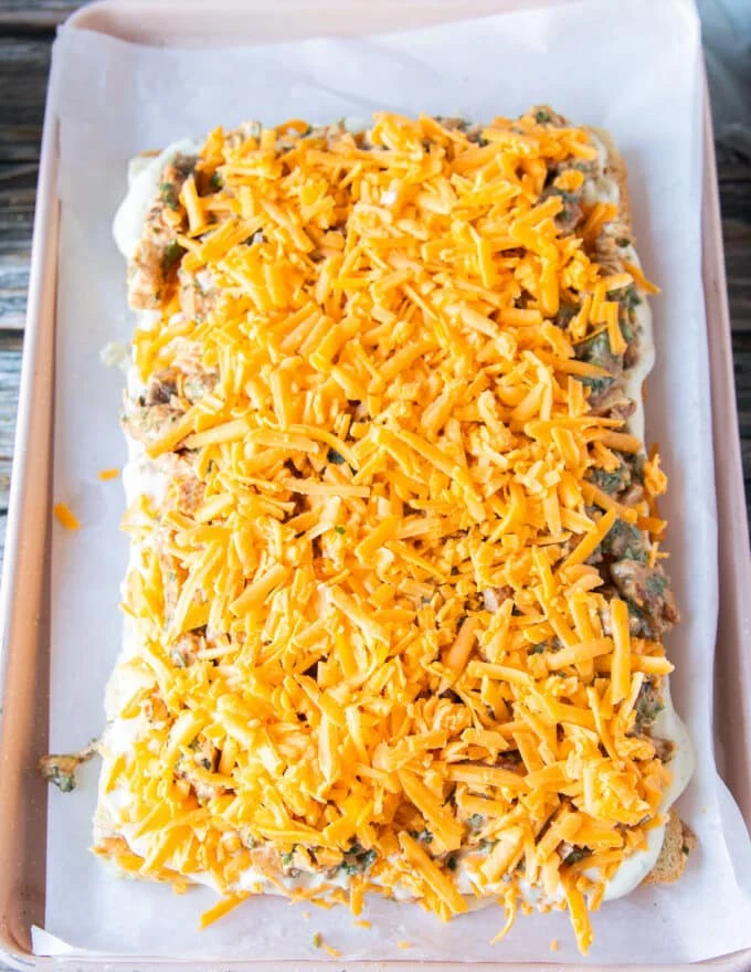 An extra layer of cheese is added over the chicken filling in the chicken sliders