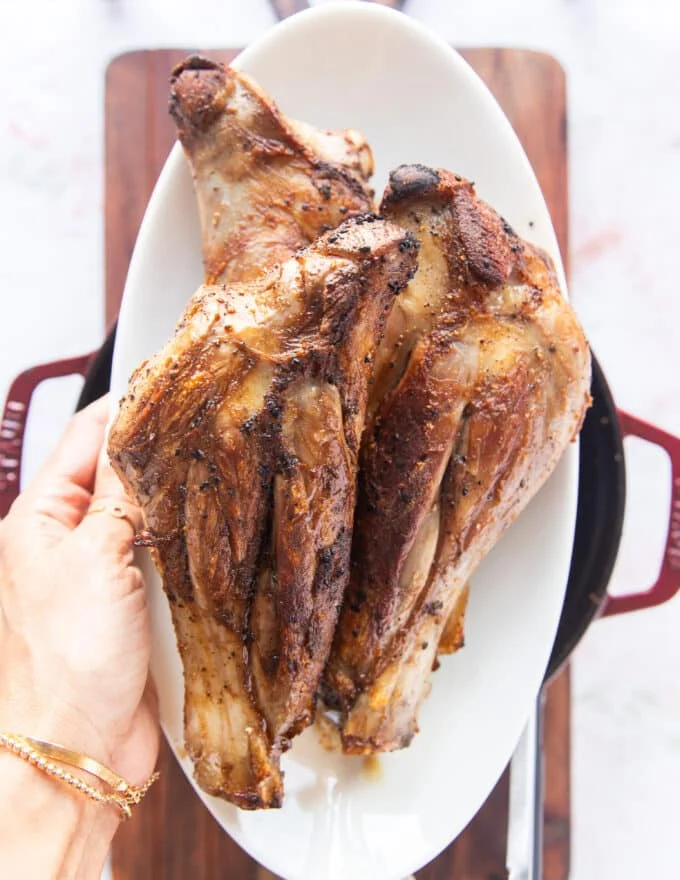 browned lamb shanks removed on to a plate to make the liquid base for slow cooking