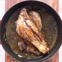 the lamb shanks and liquid are added to a slow cooker to slow cook