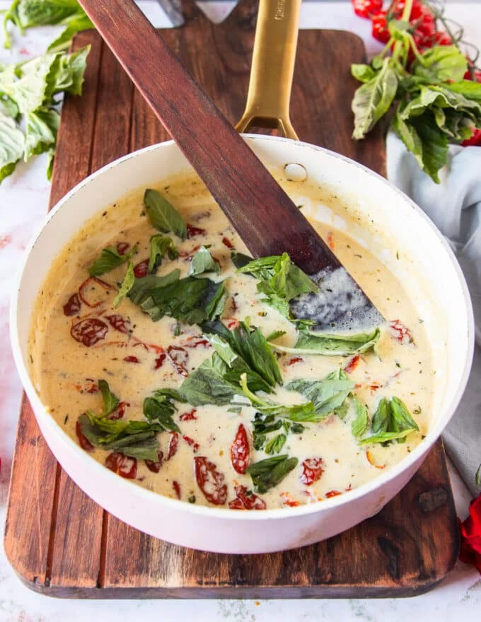 fresh basil is added ad the end of the creamy sun dried tomato sauce with parmesan