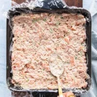 the fish mixture is now added over the avocado layer to make the filling for the sushi cake