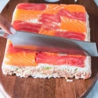 The sushi cake is inverted on to a board and then sliced or cut into small dice