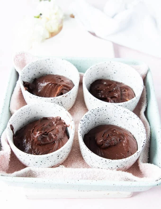 The brownie pudding batter is divided among the dishe