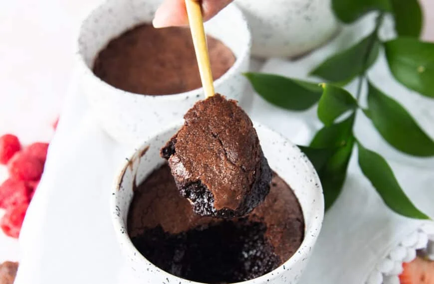 A spoon showing a scoop of the brownie pudding with the crackled tops and fudgy soft inside